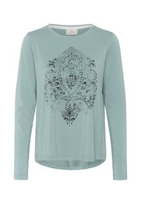 Lichtblauw langslivig T-shirt van zachte stof met een zwart ingewikkeld mandala-patroon op de voorkant, een gebogen zoom en een ronde hals.
