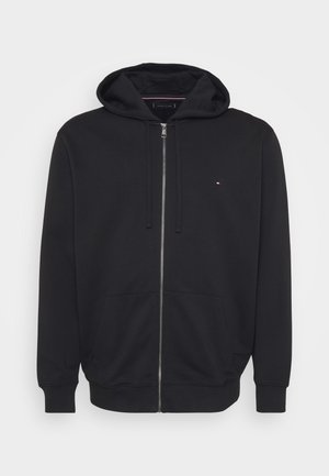 Crna zip-up dukserica s prednjim džepovima, kapuljačom na vezanje i malim crvenim, bijelim i plavim logom na lijevoj strani grudi.