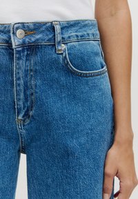 Hoge taille blauwe spijkerbroek met een klassieke pasvorm, voorzien van subtiele slijtage, een metalen knop en vijf zakken.