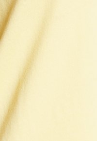 Light yellow fabric with a smooth texture, featuring a fine, even weave. Soft and slightly stretchy material, ideal for casual wear.