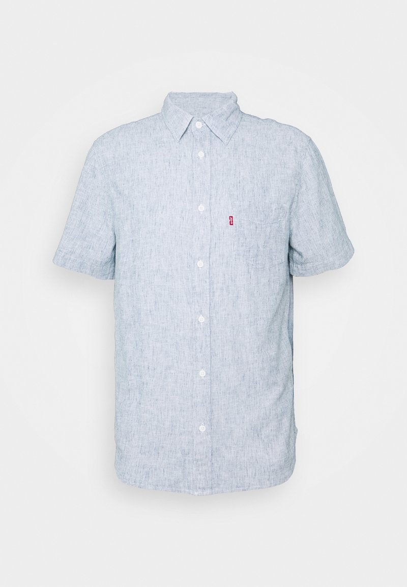 Chemise bleu clair à manches courtes avec boutons, col et poche poitrine avec une petite étiquette rouge sur fond blanc.