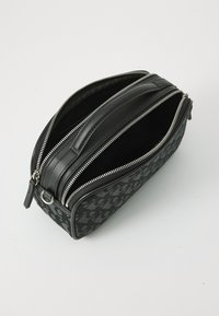 Borsa da toeletta nera con zip realizzata in tessuto testurizzato e pelle liscia, con hardware argentato e un interno con due scomparti.