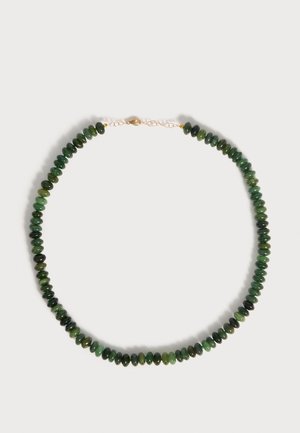 Collar con cuentas de jade verde pulido ensartadas en una cadena de oro con cierre de tipo mosquetón sobre un fondo claro.