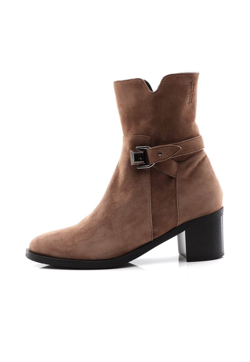 Brun mocka ankelstövel med rund tå, en medelhög klack och ett dekorativt band med en metallspänne. Har en v-formad krage.