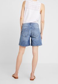 Farkkutrikoot rentona istuvana, vaaleansinisenä ja hienovaraisilla kulutustunnuksilla. Takataskut ja keskikorkea vyötärö.