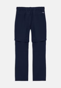 Tumši zilas softshell bikses ar elastīgu jostasvietu; ir rāvējslēdzējs, lai tās varētu pārvērst par šortiem; gluda tekstūra un bez redzamām rakstu formām.