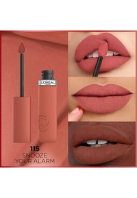 Rouge à lèvres liquide dans une teinte rose poussiéreux, mat, avec un applicateur. Comprend des échantillons sur les lèvres montrant diverses teintes de peau et une texture lisse.