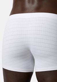Vita boxershorts med rutigt mönster, som har en slät yta, elastisk midjeband och mjuk tygtextur.