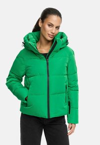 Veste matelassée verte avec capuche, fermeture éclair et poches latérales. Présente une texture lisse et des fermetures éclair noires contrastantes.