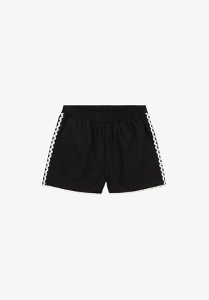 Shorts noirs à taille élastique avec bordure blanche festonnée le long des côtés et de l'ourlet, posés à plat sur fond blanc.