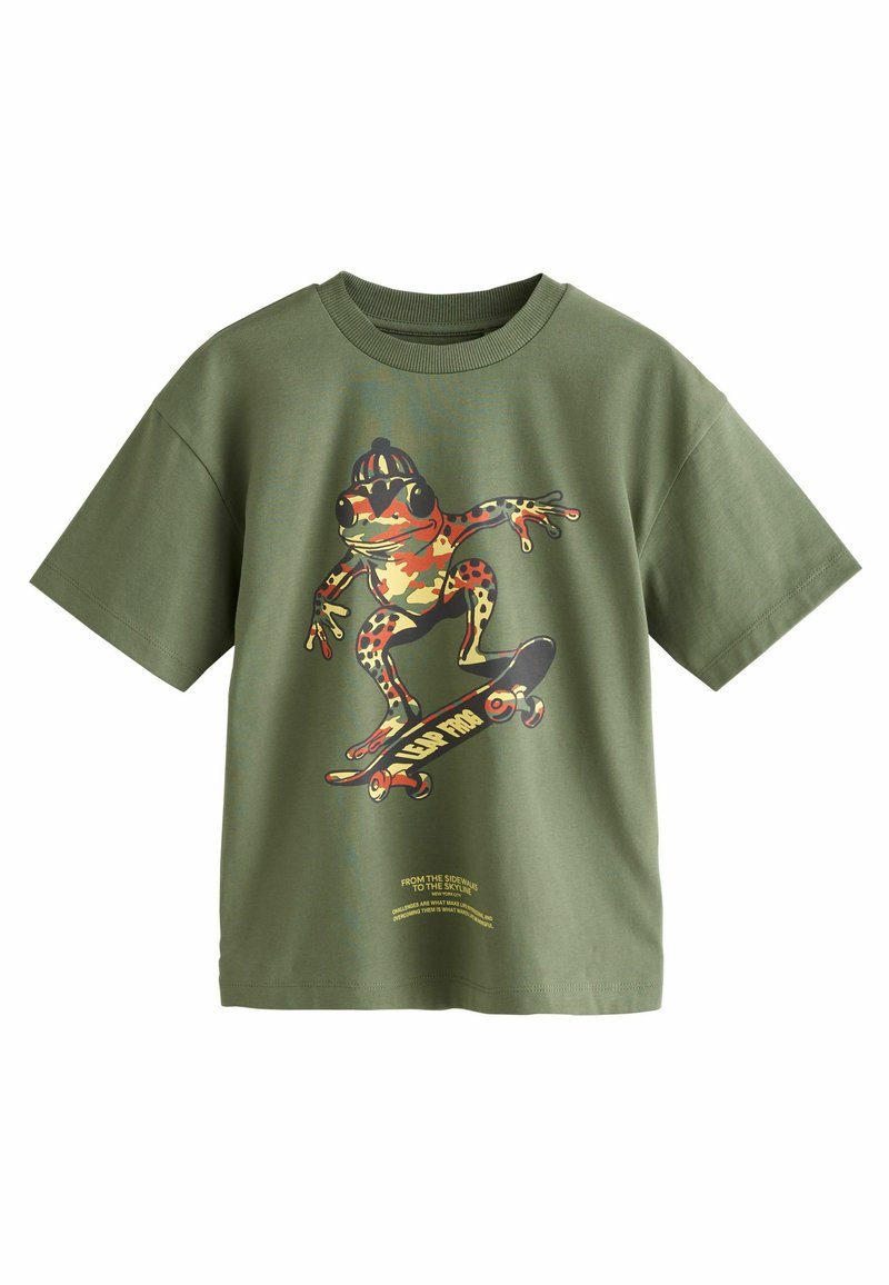 T-shirt di cotone verde con una grande grafica di una rana che fa skateboard in colori vivaci, con maniche corte e design a collo rotondo.