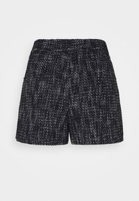 Shorts texturés taille haute noir et blanc avec taille élastique, coupe ajustée et motif tissé subtil.