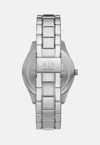 Roostevabast terasest kell, millel on harjatud viimistlus. Omab asetatud rihma kujundust, logo graveeringut ja ümmargust korpust. Minimalistlik stiil.