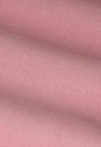 Tissu rose doux avec une texture lisse, présentant un motif de tissage subtil et un léger éclat, agencé en douces plis.