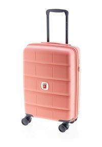 Valise rigide de couleur corail clair, de forme rectangulaire, surface texturée avec des rainures, poignée noire rétractable et quatre roues.