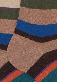 Primo piano di calze di lana a righe colorate con bande marroni, blu, verdi, viola, arancioni e teal.