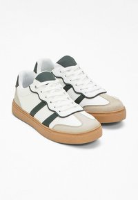 Sneaker bianchi con dettagli verdi, caratterizzati da un tessuto testurizzato e una suola in gomma. Design con lacci e sovrapposizioni in contrasto, con una finitura liscia.