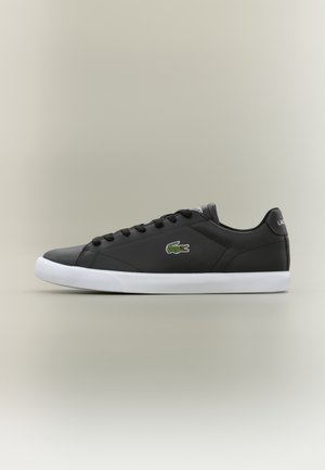 Czarny niski sneaker z białą podeszwą, sznurowany z przodu, z zielonym logo krokodyla po boku, pokazany z profilu na neutralnym tle.