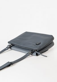 Grau Leder Umhängetasche mit glatter Oberfläche, Reißverschluss und verstellbarem Tragriemen. Verfügt über eine vordere Reißverschlusstasche und ein minimalistisches Design.
