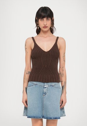 Maiou tricotat maro texturat cu decolteu adânc în V, asortat cu o fustă din denim bleu deschis, cu tiv evazat. Ambele articole sunt mulate.