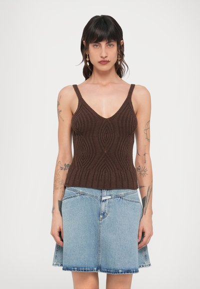 Débardeur marron en maille texturée avec un décolleté en V profond, associé à une jupe en jean bleu clair avec un ourlet évasé. Les deux vêtements sont ajustés.