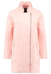 Abrigo largo rosa con acabado texturizado, que cuenta con un cuello alto, cierre asimétrico y bolsillos laterales. Diseño limpio y moderno.