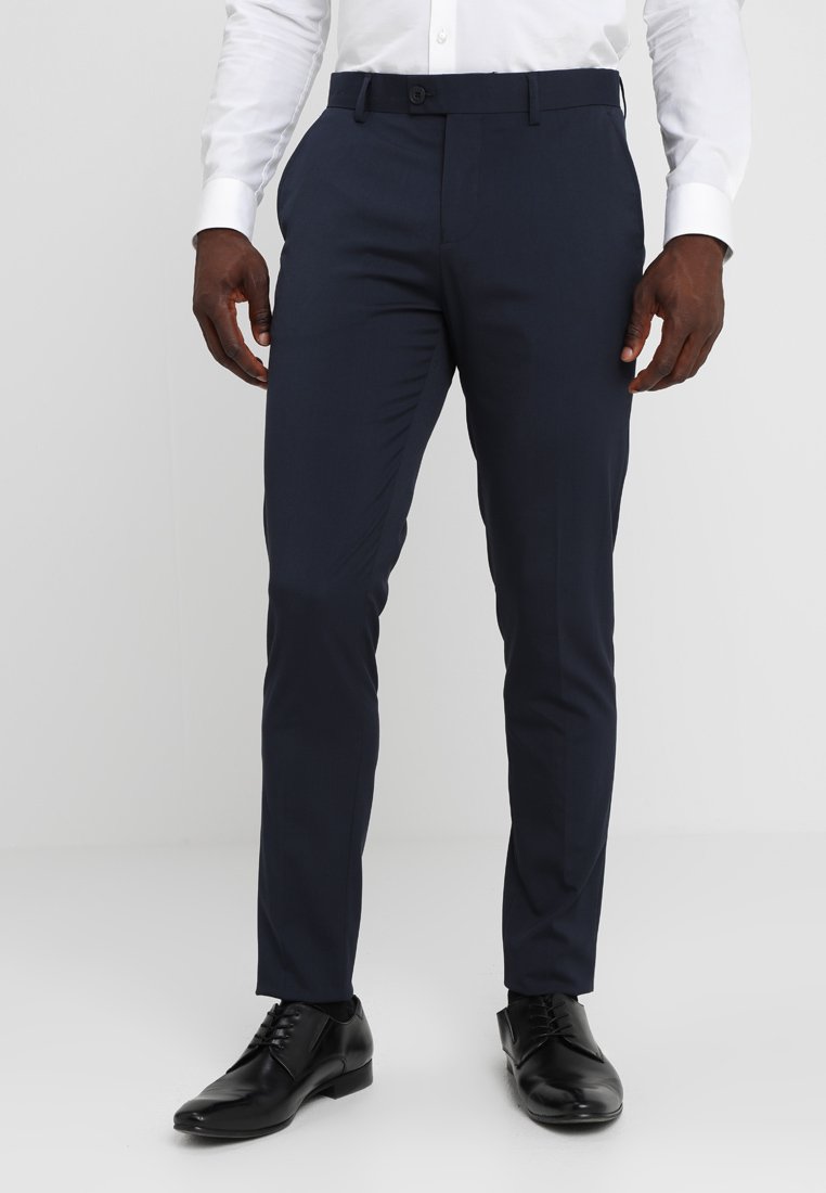 Navy Slim-Fit-Hosen aus maßgeschneidertem Stoff, mit flacher Vorderseite, Gürtelschlaufen und Seitentaschen, kombiniert mit schwarzen Dressschuhen.