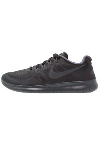 Scarpa sportiva nera con tomaia in rete, logo Nike tono su tono, suola in gomma flessibile e dettagli testurizzati; presenta lacci grigi e accenti.