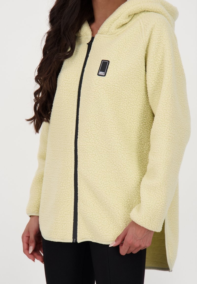 Ljusgult fleece-hoodie med texturerad yta, frontdragkedja och sidorevor. Har en liten svart logotyp på bröstområdet.