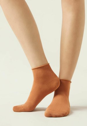 Calcetines de tobillo color cobre, hechos de un material suave y elástico, con un puño sin costuras y una textura suave. Adecuados para uso casual.