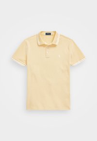 Pikétröja i mjuk gul bomull med klassisk krage, treknappslås och vita randiga detaljer på kragen och ärmarna.