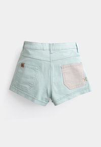 Shorts en denim vert menthe clair à taille haute, ornés de deux poches arrière – l'une avec un panneau en tissu beige clair et une broderie subtile.