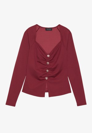 Bordo majica dugih rukava s V izrezom, nabranim detaljima sprijeda i pet ukrasnih dugmadi duž patenta.