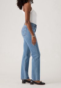 Jeans azzurri a vita alta con gamba dritta, realizzati in denim, con due tasche posteriori e un dettaglio con logo cucito.