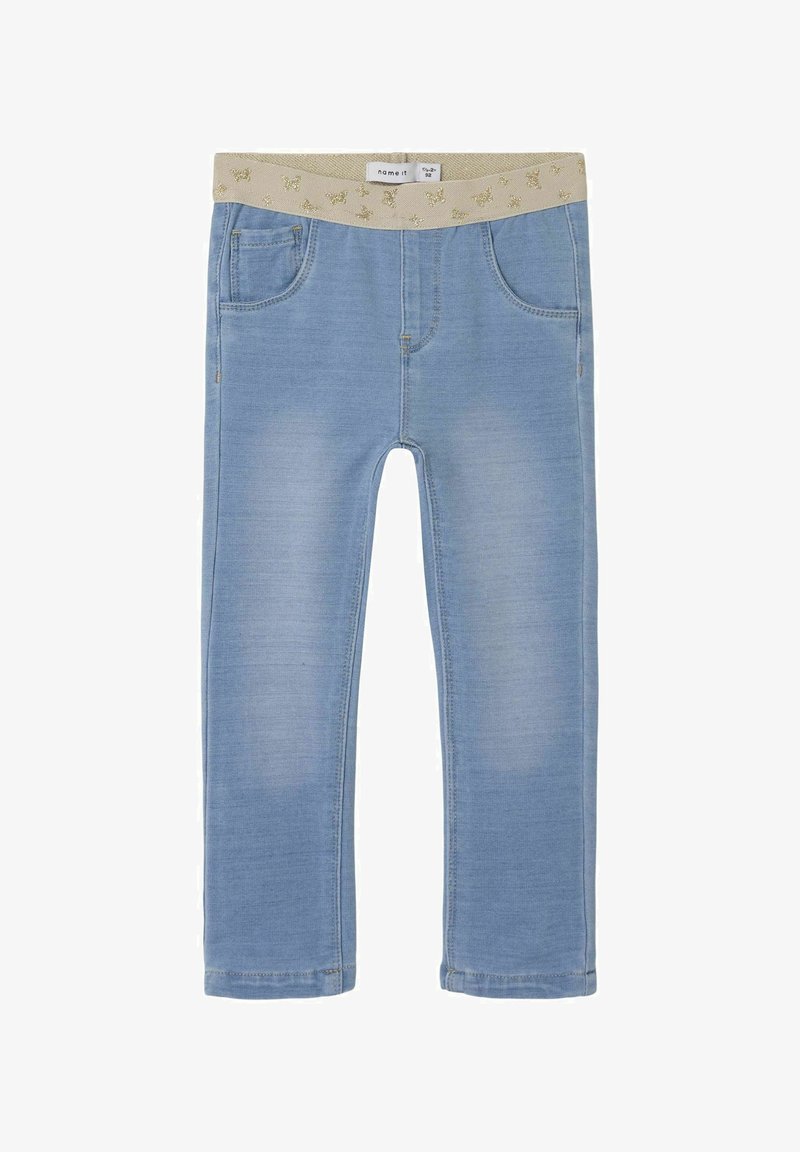 Jeans de color azul claro con una cinturilla elástica beige brillante, que cuentan con cinco bolsillos y un diseño ajustado. Textura de mezclilla suave con un ligero desvanecimiento.