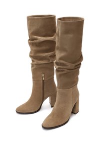 Taupe suède laarzen tot de knie, met een slouchy design, puntige neus en een zijrits met een blokhak. Zachte textuur overal.