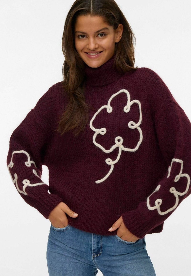 Burgundska turtleneck pulover, izdelan iz teksturiranega pletenega materiala, z belimi cvetličnimi vzorci na telesu in rokavih. Priložnostna prileganje.