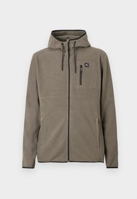 Καφέ φλις μπουφάν με φερμουάρ και κουκούλα, τσέπη με φερμουάρ στο στήθος, κορδόνια, και πλευρικές τσέπες, τοποθετημένο σε λευκό φόντο.