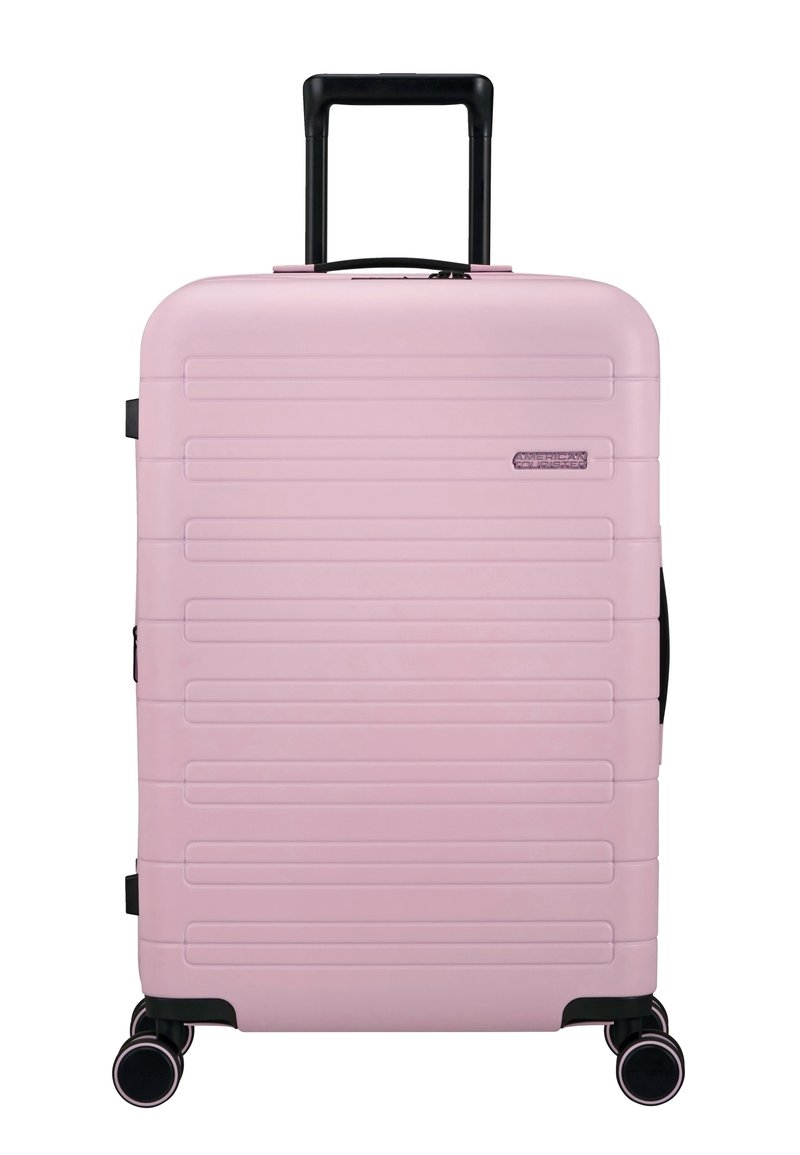 Valise rigide rose avec des rainures horizontales, accents noirs, poignée télescopique et quatre roues multidirectionnelles pour un transport facile.