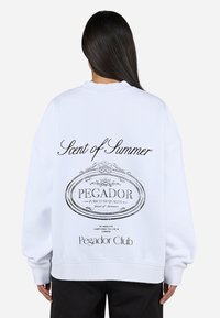 Witte sweatshirt met een ontspannen pasvorm, voorzien van zwarte tekst en een graphic op de achterkant, met de tekst "Scent of Summer" en het merk "Pegador."