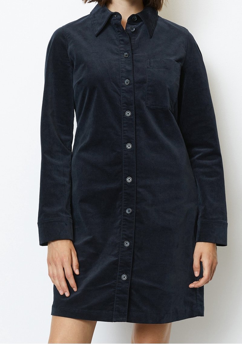 Abito camicia navy con bottoni in tessuto morbido, caratterizzato da maniche lunghe, colletto, tasca sul petto e un design a taglio dritto con una texture liscia.