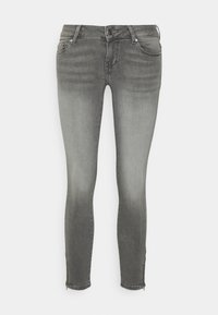 Úzke džínsy z vyblednutého šedého denimu. Majú zips na členkoch, päť vreciek a klasické pútka na opasok. Mäkký povrch s miernym elastanom.