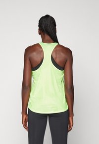 Světlý zelený síťovaný tílko s designem racerback, který má lehkou texturu a černé akcenty na ramínkách.