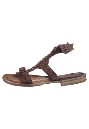 Sandale en cuir marron avec une semelle plate, présentant un design à bride en T, des coutures décoratives et une boucle réglable pour la fermeture.