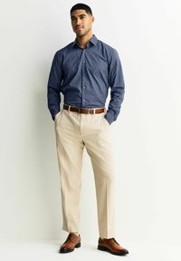 Granatowa koszula w kratę na guziki, beżowe spodnie, brązowy skórzany pasek i pasujące buty. Gładka tkanina, dopasowany krój i uporządkowany design.