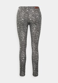 Jeans ajustados em estampado de cobra preto e branco, com um padrão texturizado, cintura padrão e bolsos traseiros para maior praticidade.
