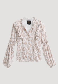 Blouse blanche à manches longues avec imprimé floral marron, col volanté et devant volanté, fermeture boutonnée et manches froncées.