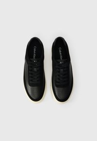 Μαύρα sneakers με συνδυασμό λείας και τρυπητής δερμάτινης επιφάνειας, με σχέδιο που δένει με κορδόνια και κρεμ καουτσούκ σόλα. Διακοσμημένα με λογότυπο.