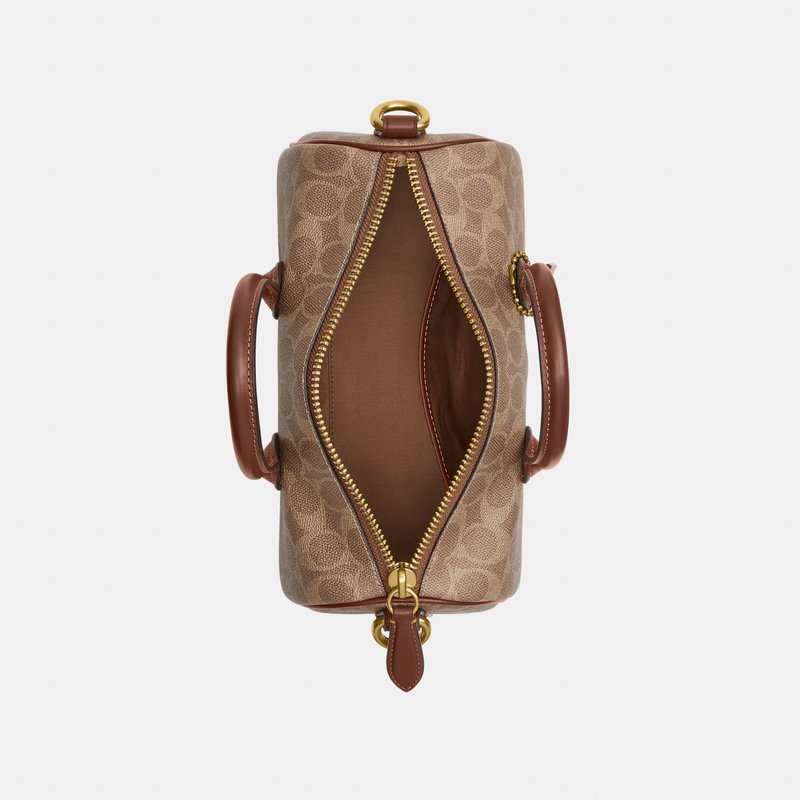 Bolso marrón con estampado, con asas dobles de cuero, cremallera abierta que revela un interior de cuero liso con un bolsillo interno.