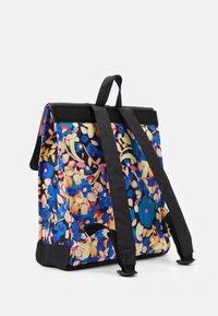 Sac à dos à motifs floraux dans des teintes de bleu, rose et jaune. Fabriqué en tissu avec une surface texturée. Dispose de bretelles noires et d'une poignée supérieure.